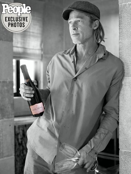 Brad Pitt segurando a garrafa de Fleur de Minalva